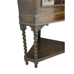 Early 20th century oak corner display cabinet, enclosed by glazed door, on spiral turned supports joined by undertier 