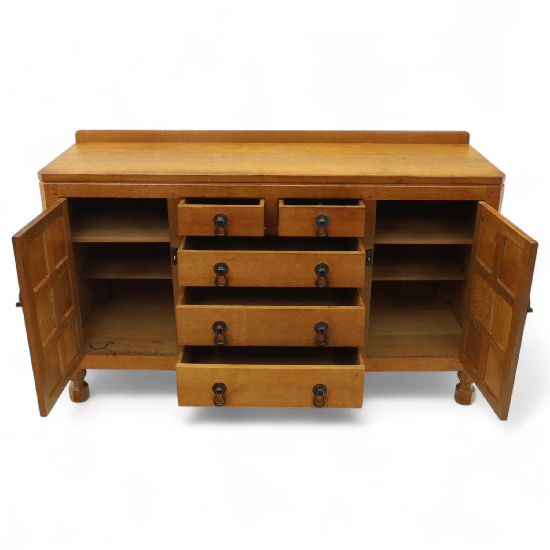 Mouseman - oak sideboard with adzed top and raised gallery back, over two short drawers and three long drawers, flanked by panelled cupboard doors with wrought iron fittings, on octagonal feet, carved with the signature mouse to the right-hand door