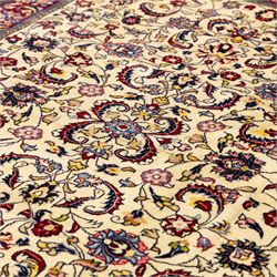 West Persian Sarough hand-knotted rug, ivory field decorated with finely drawn symmetrical lattice of scrolling vines, palmettes and flowering sprays issuing from a subtle central medallion, enclosed by a broad madder-red border of stylized palmettes and foliate vine ornament between multiple guard stripes, with cotton fringe ends 