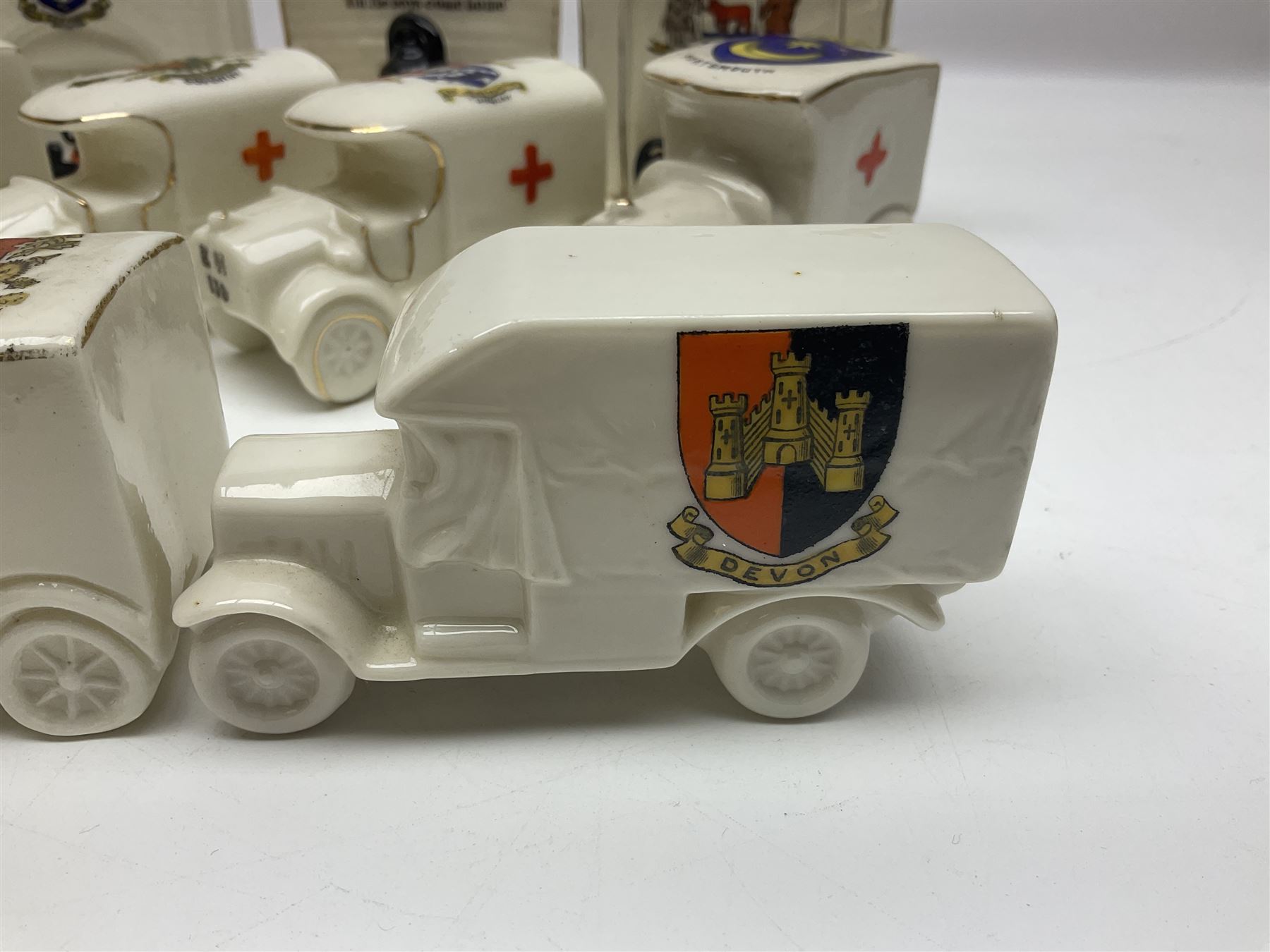 Ten WW1 crested china military models comprising seven field ambulances and three 'Home Fires Burning' fire-surrounds/range; various makers including Willow Art, Arcadian China, Grafton China, Savoy China, Carlton China etc; various crests including Devon, Aldershot, Portsmouth, West Ham, Coventry, Oxford, Hastings, Brighton etc (10)