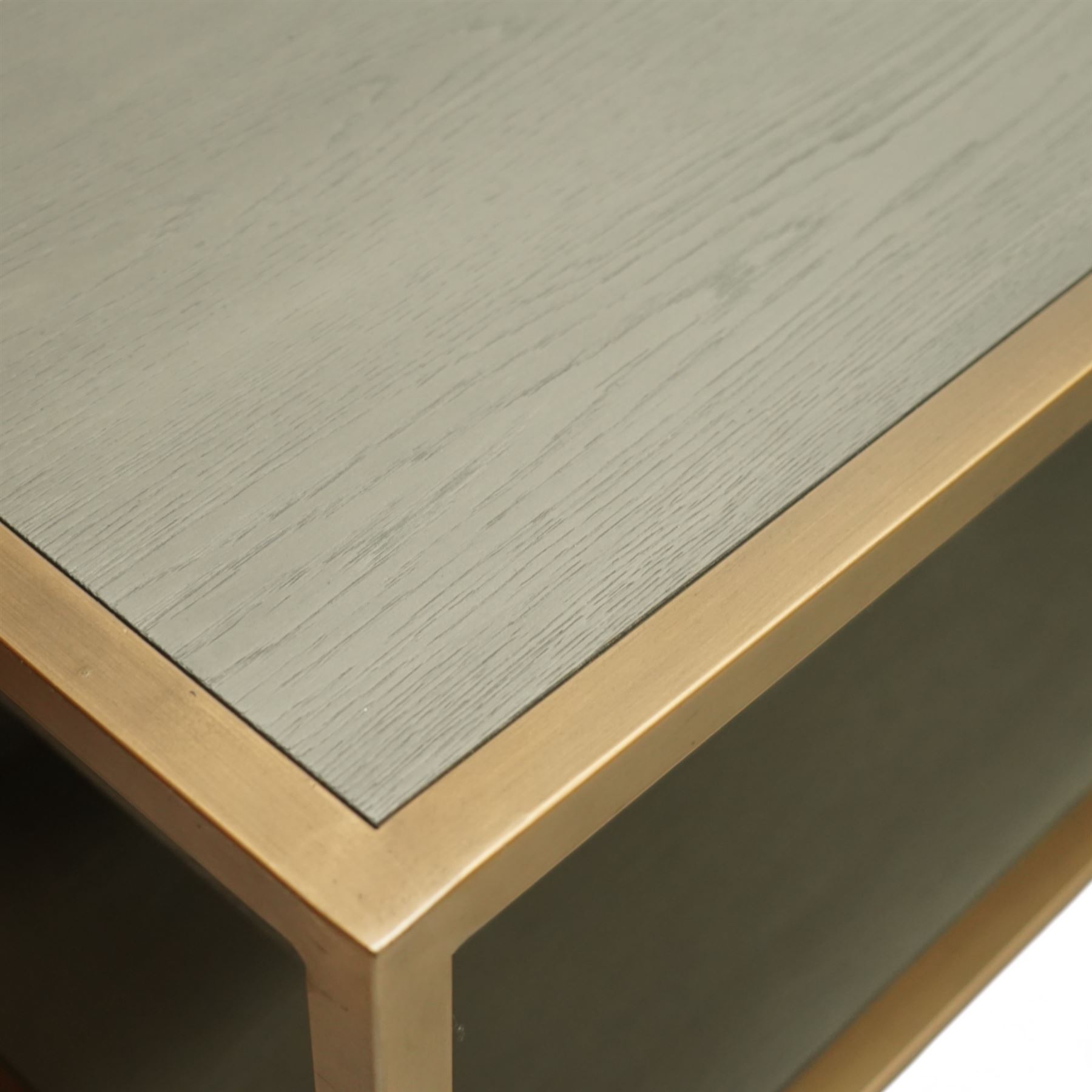 Contemporary low television stand, brass-effect metal frame enclosing six open oak veneered compartments, raised on square tubular supports
