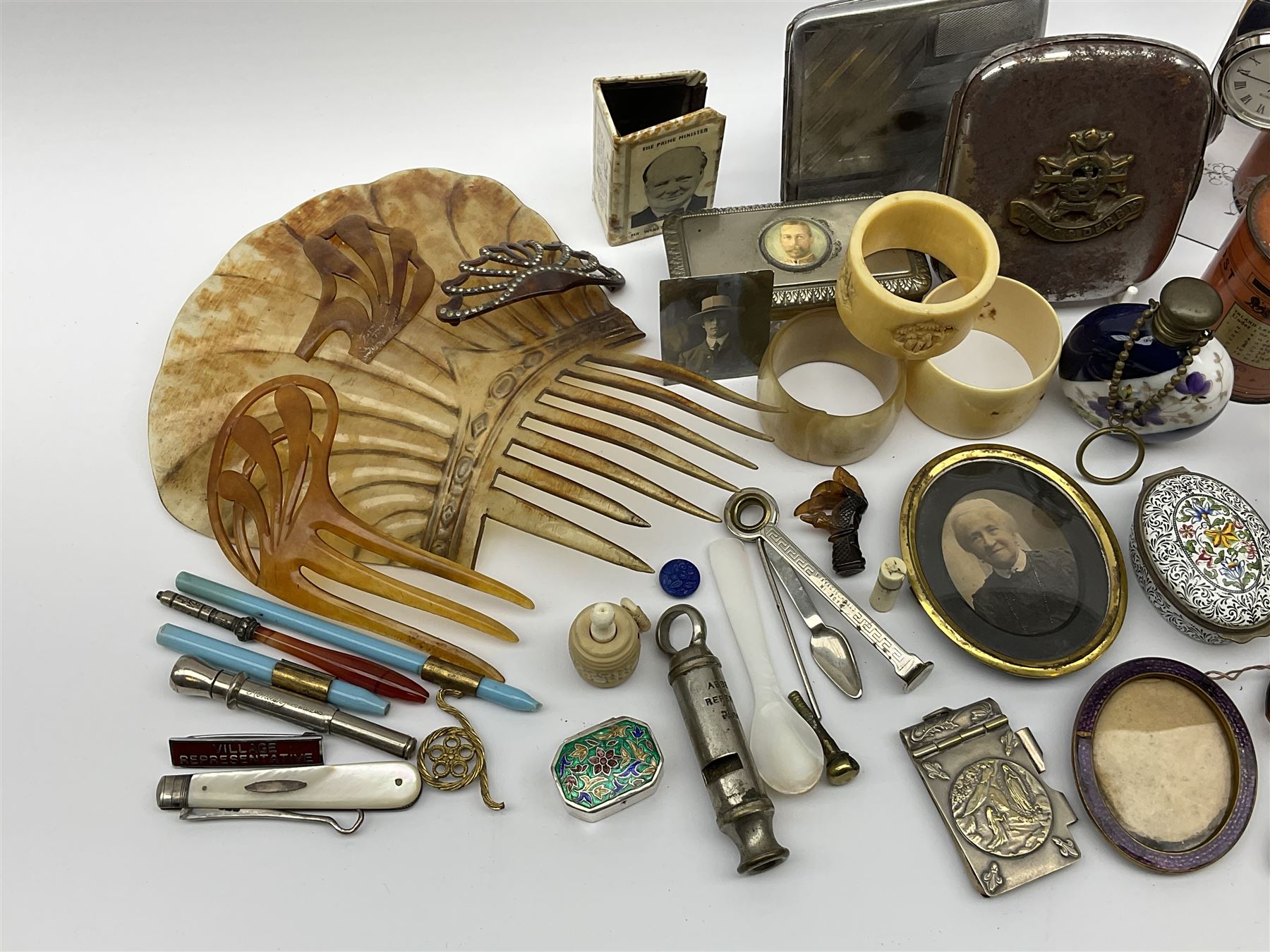 A group of assorted collectables, to include small oval purple guilloche enamel frame, WWII matchbox holder depicting Winston Churchill, Halcyon Days enamel box, Ronson table lighter, ebonised glove stretchers, ivory napkin ring, mother of pearl handled button hook, engine turned cigarette case, etc. 