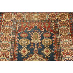 Caucasian hand-knotted runner, dark navy ground with three ivory geometric medallions surrounded by stylised flowerheads and angular motifs in madder red, green and ivory, enclosed by repeating geometric borders