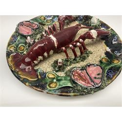 Two 20th Century Portuguese Palissy style Majolica wall plates, one depicting a crab, the other a lobster each to the centre modelled in relief surrounded by encrustations and shells, both with impress marks beneath, D34cm
