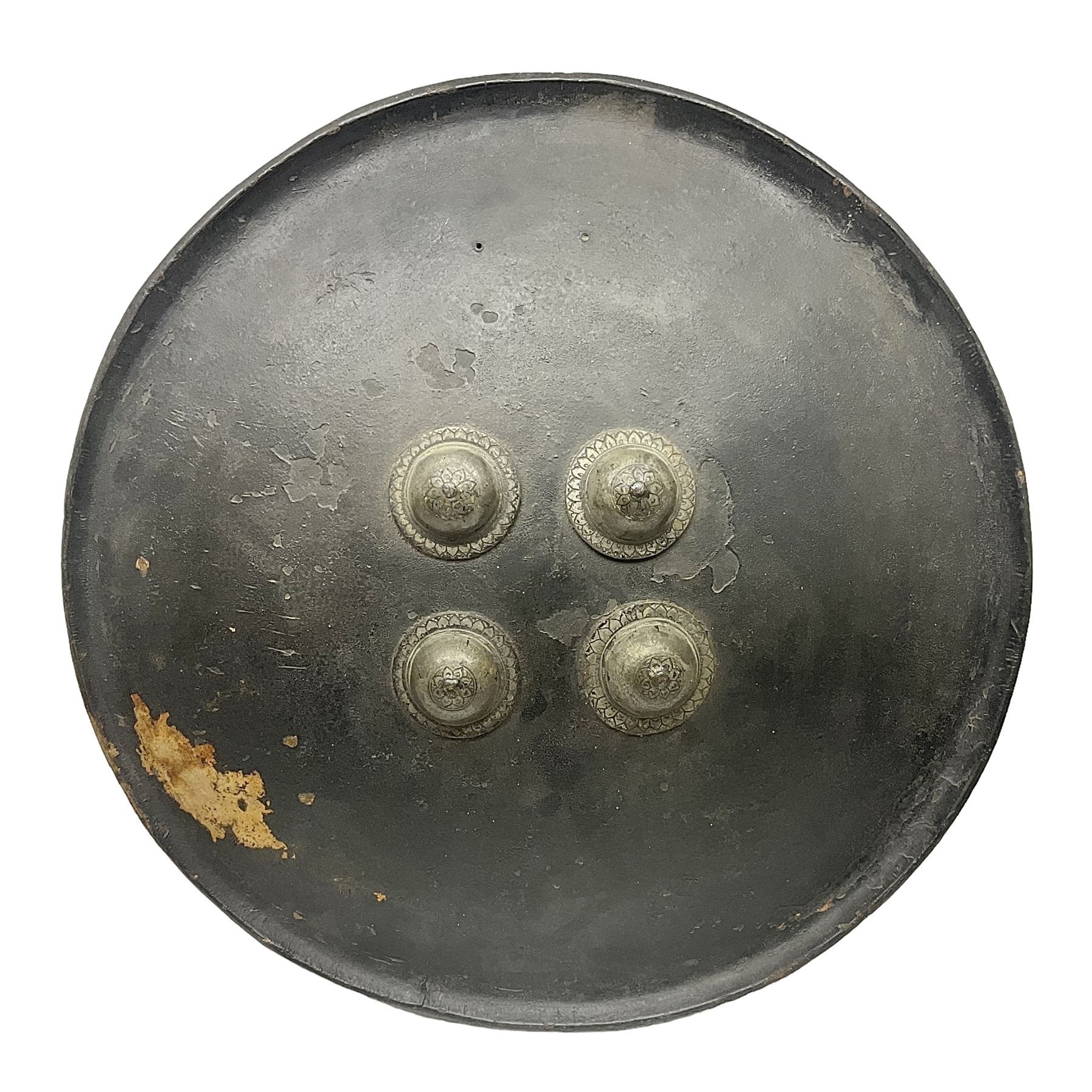 Indian black lacquered hide shield/dhal, of circular convex form with strongly outward-turned brim, fitted at its centre with four metal bosses, each of hemispherical form, with traces of silvered foliate decoration, the bosses corresponding on the inside with four iron rings for enarmes D49cm