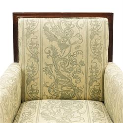 William IV rosewood framed library armchair, squared form with green on ivory ground upholstery, moulded lower seat rail with applied roundels over reeded supports, terminating to brass cups and castors