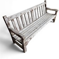Teak garden bench with slatted back and seat on square supports in weathered which finish 