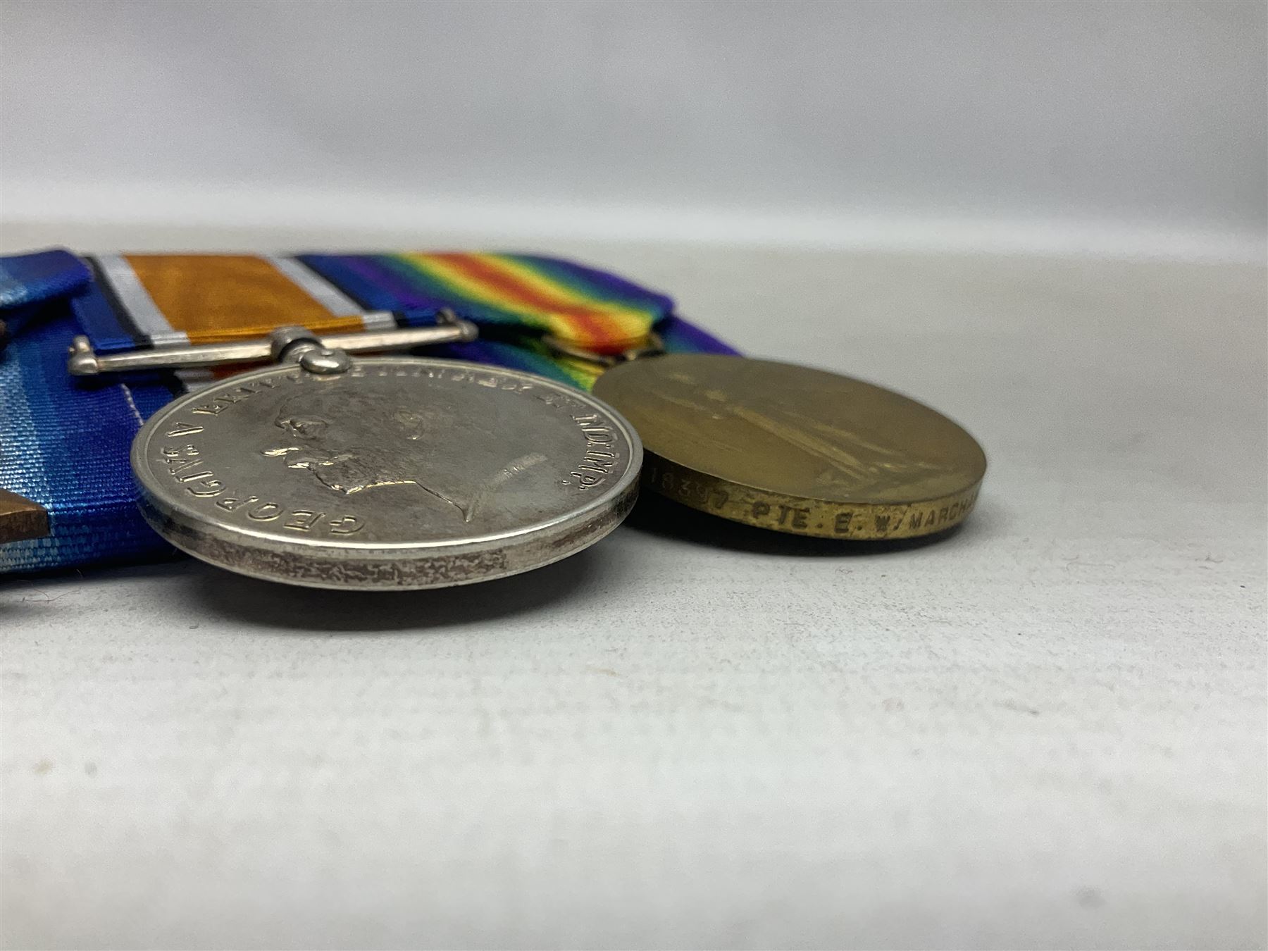 WW1 group of three medals comprising British War Medal, 1914-15 Star and Victory Medal together with bronze Memorial Plaque named to 18397 Pte. E. W. Marchant Y. & L. R.; with ribbons; displayed on modern board for wearing