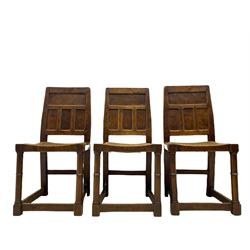 'Gnomeman' set of three oak dining chairs, panelled backs over curved seat rails with drop in rope rush seats, turned front supports with collar joined by plain stretchers, two with carved seated gnome figures, painted

Provenance - This collection of early 'Gnomeman' furniture comes to us directly from the Whittaker family. The pieces were made by the vendor's father Thomas Whittaker in the 1930/40s for his own use. During this time, he lived in York and made items for himself and friends. Whittaker adopted the gnome as a signature and trademark after his move to Littlebeck, Whitby.
