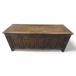 18th century oak five panel chest, with planked top with chamfered edges, hinged top enclosing two candle boxes, five fielded panels flanked by foliate carvings, raised on stile supports