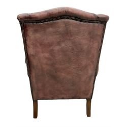 Georgian style wingback armchair, upholstered in leather with studded detail, on square moulded supports joined by plain stretchers 