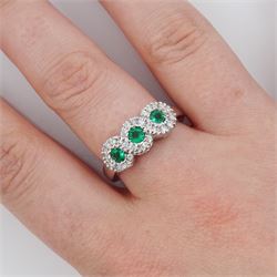 18ct white gold emerald and diamond triple cluster ring, three round cut emeralds, surrounded by round brilliant cut diamonds, the gallery with pierced trefoil motifs, stamped, total emerald weight approx 0.30 carat, total diamond weight approx 0.30 carat