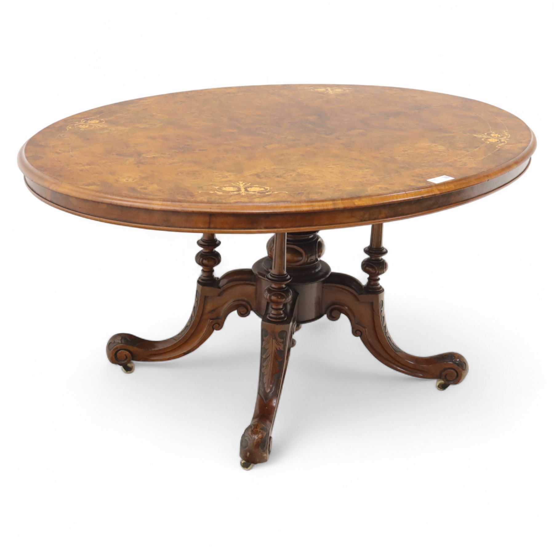 Victorian inlaid burr-walnut and marquetry oval centre table, quarter veneered tilt-top with scrolling foliate and floral marquetry reserves on a turned carved column with clustered supports raised on four out-swept scroll legs on ceramic castors  