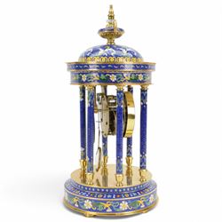 20th century- 8-day cloisonne styled rotunda clock, with six decorative enamel pillars and floral decoration to the base and top, visible pendulum with a portrait depiction of a young lady, four inch enamel dial with Roman numerals, minute markers and trefoil steel hands, twin train spring driven rack striking movement sounding the hours and half hours on a coiled gong.   