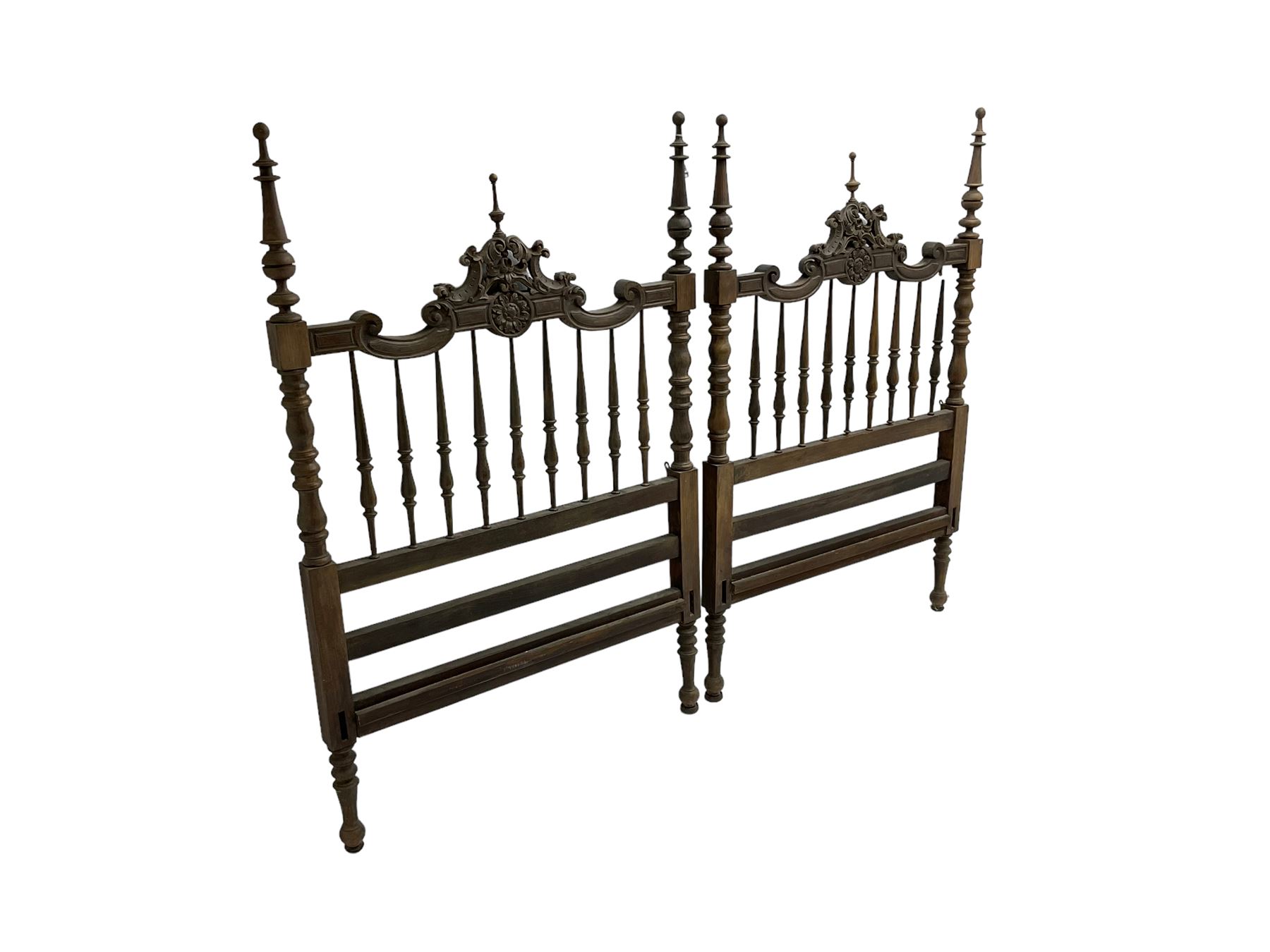 Pair Spanish stained beech single 3' bedsteads, spindle turned backs and carved with scrolling floral decoration 
