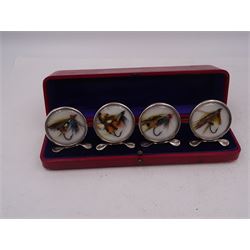 Set of four early 20th century silver mounted place card holders, each of circular form and set with a coloured fly fishing hook behind a glazed panel, upon three pad feet, hallmarked Grey & Co, Chester 1912, H4.5cm, contained within red fitted case, with purple silk and velvet interior