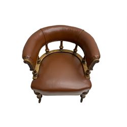 19th century oak tub shaped library chair, the curved upholstered back rail on turned balustrade, on turned front supports with brass and ceramic castors, scroll carved cabriole rear supports, sprung seat