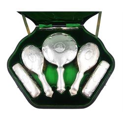 Edwardian silver mounted six piece dressing table set, comprising hand mirror, two hair brushes, two clothes brushes and comb, each with planished decoration and monogrammed cartouche, hallmarked Cornelius Desormeaux Saunders & James Francis Hollings (Frank) Shepherd, Chester and Birmingham 1908, within green velvet and silk lined in fitted case