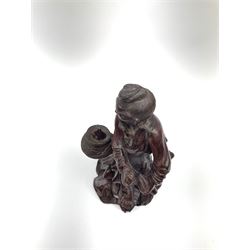 A Chinese carved hardwood figure, modelled as a fisherman with basket containing fish, with inset eyes and teeth, H25.5cm. 