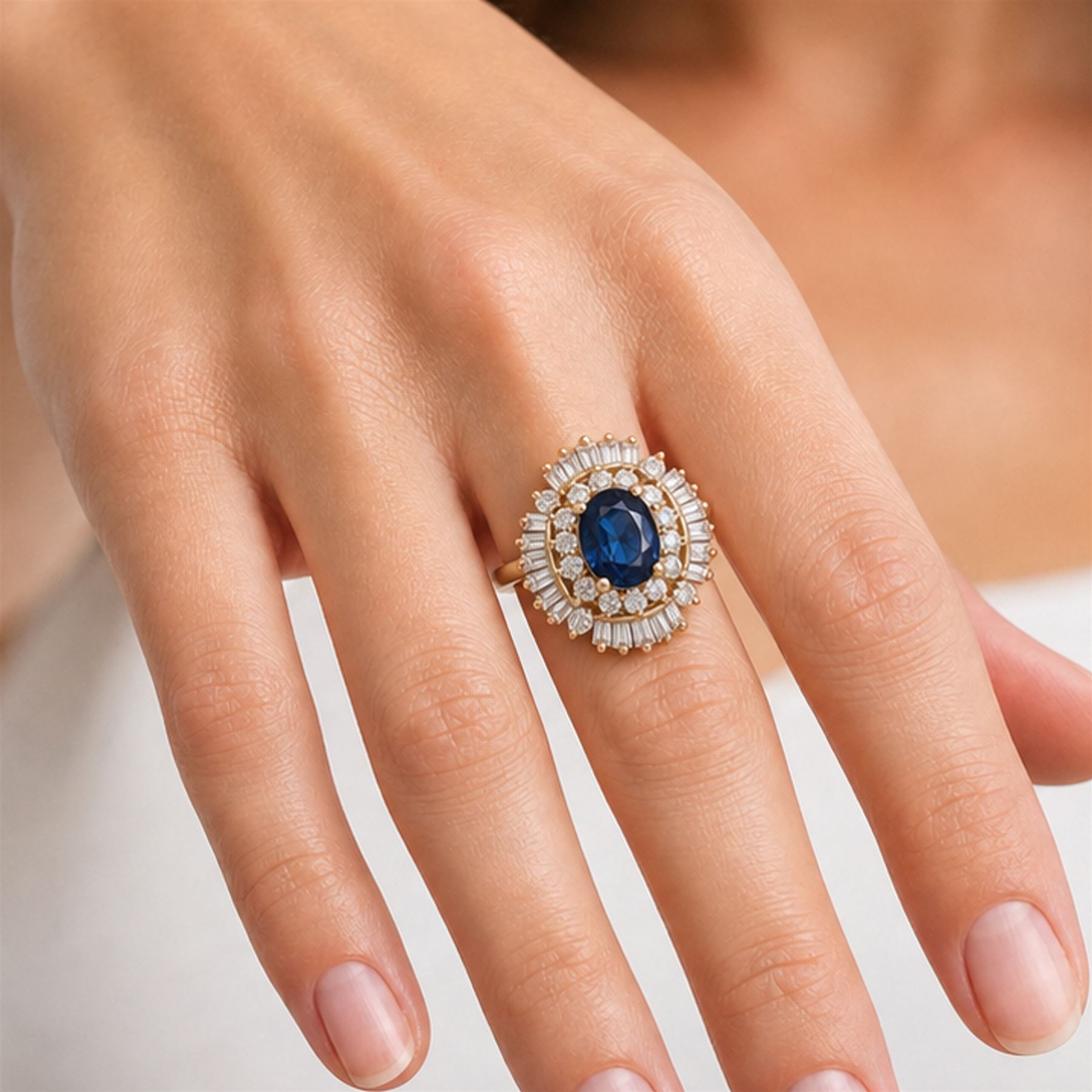 18ct gold sapphire and diamond cluster ring, single oval cut sapphire of approx 2.05 carat, surrounded by two rows of round brilliant cut and baguette cut diamonds, Sheffield import mark 1994, total round cut diamond weight approx 0.55 carat