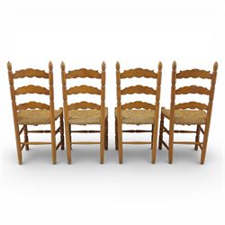 Late 20th century pine farmhouse dining table and four chairs, the rectangular plank top with rounded corners over two frieze drawers fitted with turned knob handles, raised on turned legs, the chairs with shaped ladder backs and turned finials, rush seats in a herringbone weave, on turned supports united by stretchers