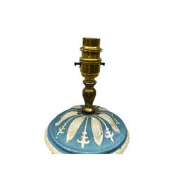 Ceramic urn shaped table lamp on a square pedestal base, decorated with relief studies of cherubs and foliage, on a blue ground, together with a cream pleated lampshade H60cm. 