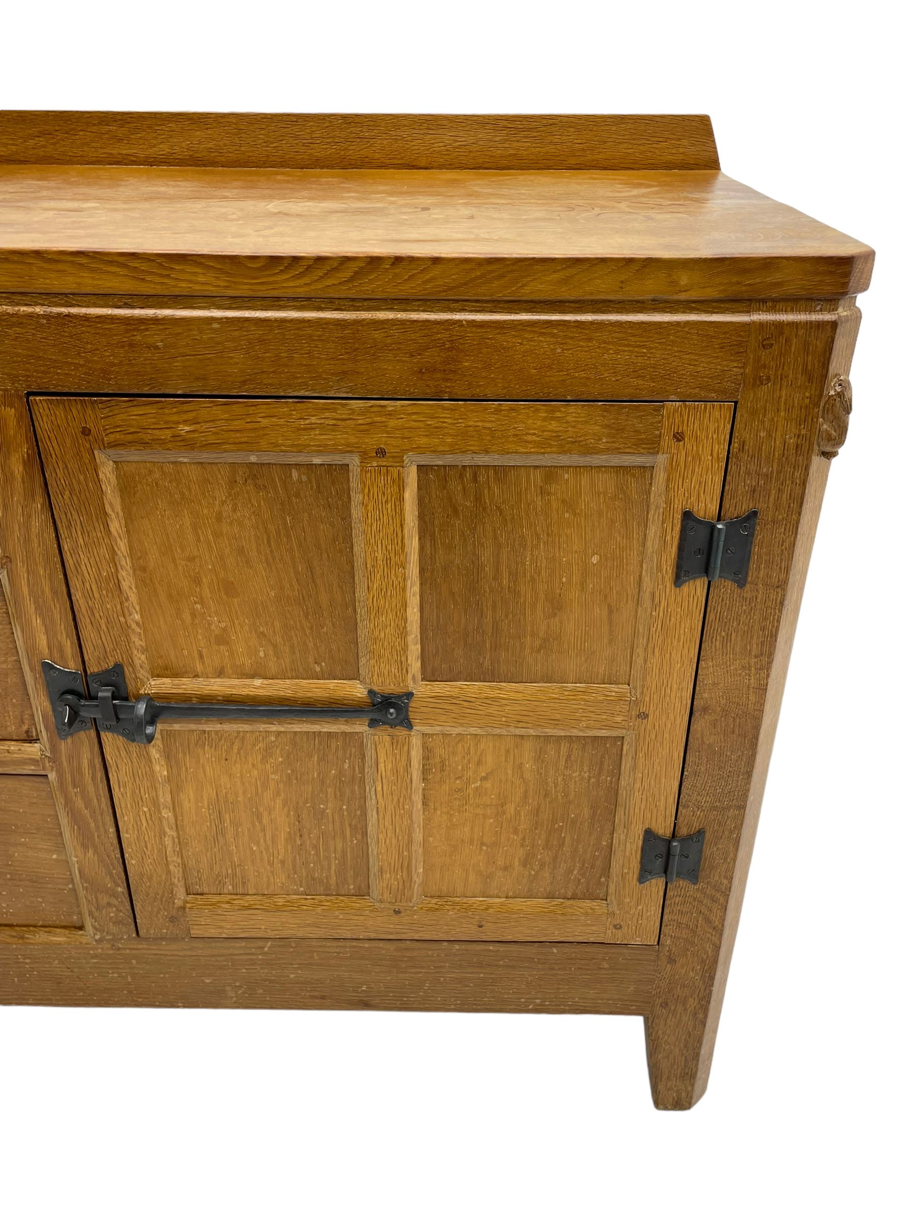 Rabbitman - adzed oak sideboard, fitted with three central drawer and two flanking cupboards, panelled doors with iron latches and hinges, carved with rabbit signature, by Peter Heap, Wetwang
