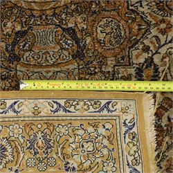 Persian Kashan design silk and wool blended rug, with a central medallion incorporating vases and scrolling floral motifs, set against a dark blue and ivory ground within a patterned border, some fraying to end fringes