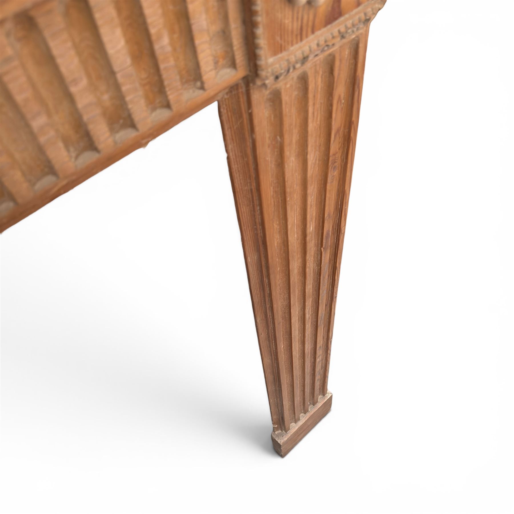 19th century Adams design pine fire surround, egg-and-dart carving over Vitruvian scrolls and fluted frieze, decorated with applied carved festoons and garlands, on fluted uprights
