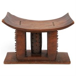 African carved hardwood headrest, having flared edges, raised on a stepped plinth base wit...