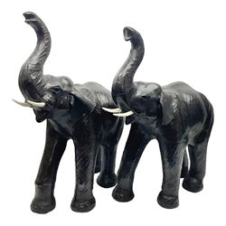 Pair of Liberty style leather bound elephants, with raised trunks, tallest H75cm