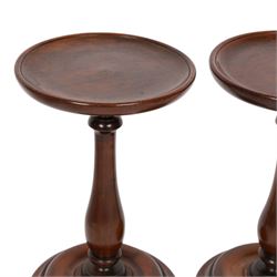 Pair of 19th century turned mahogany candle stands, each with circular top upon a baluster stem and circular stepped base, H25.5cm