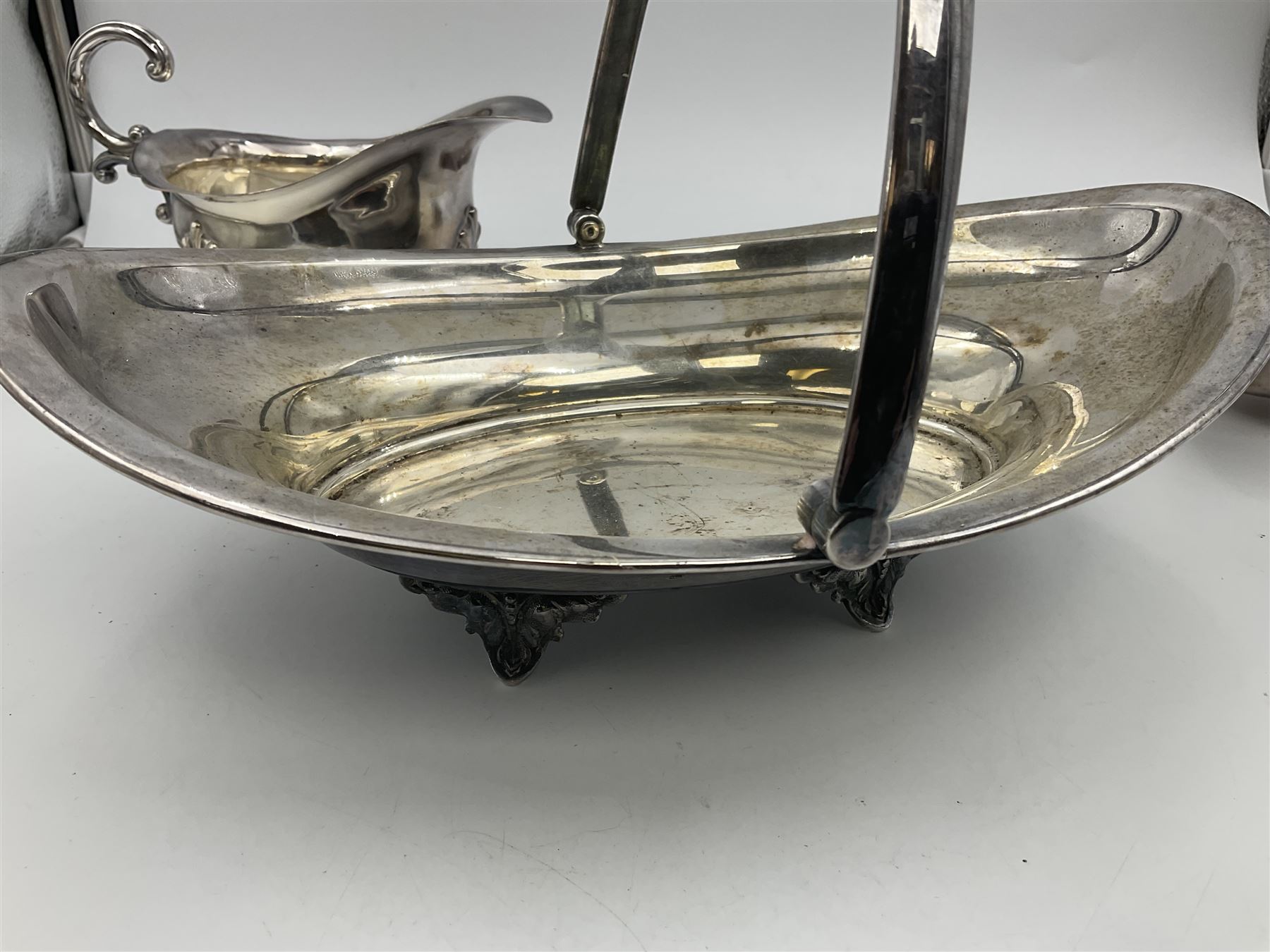 Silver plated seven bar toast rack by Mappin & Webb, together with other silver plated items including pair of bottle coasters, swing handled baskets and two sauce boats