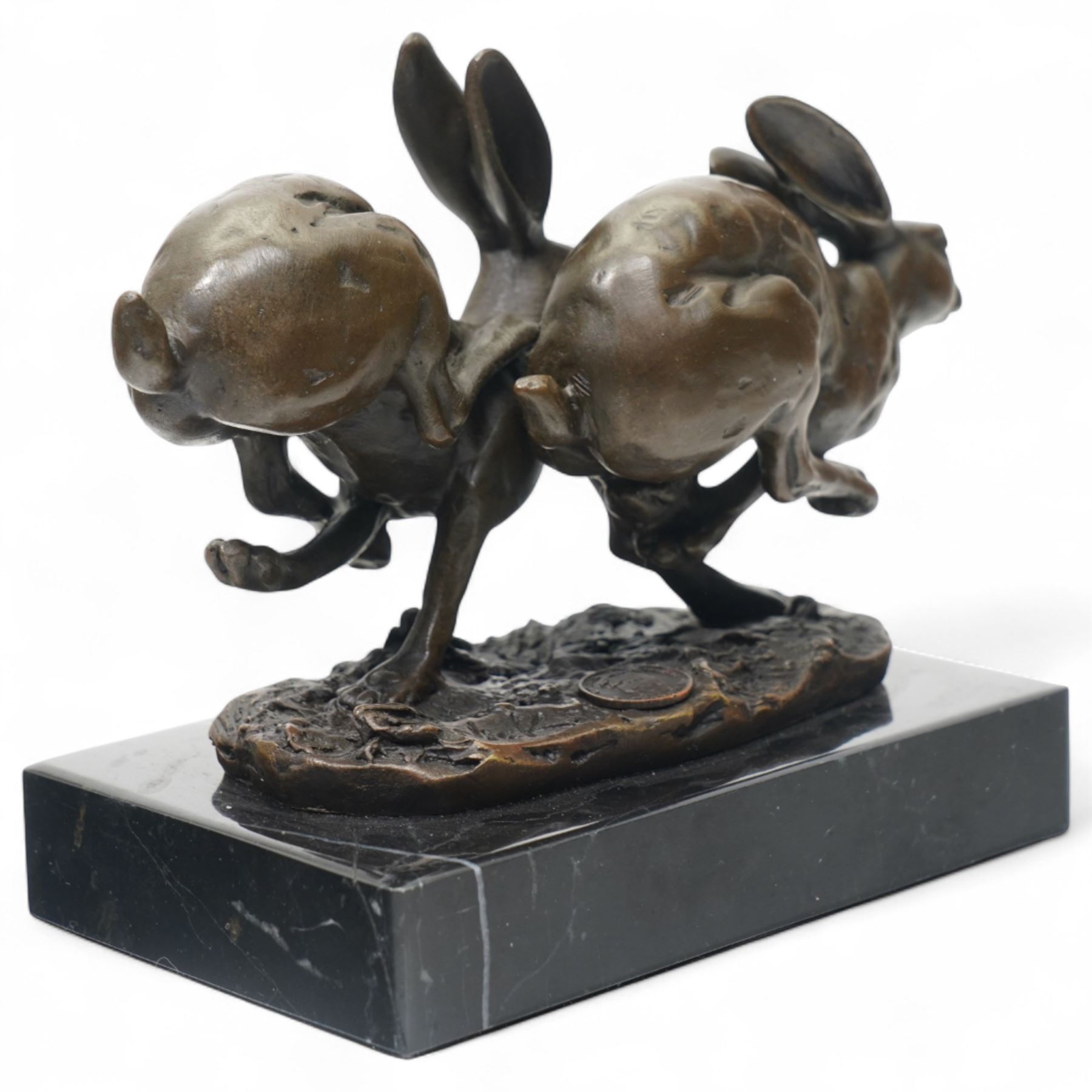 Bronze figure group modelled as two hares in chase, signed Nick and on marble base H12cm