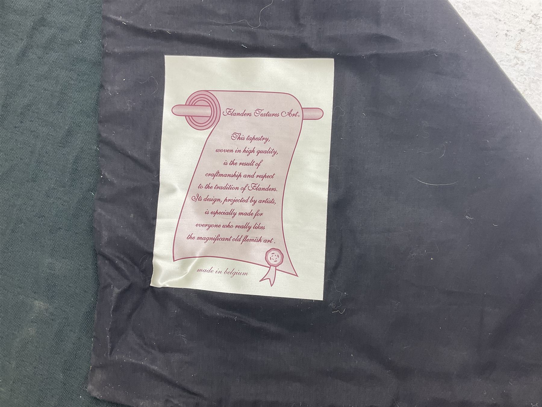 Three tapestries comprising 20th century wool tapestry panel of a medieval nobleman upon a horse with a castle in the distance, together with a smaller tapestry depicting The English Coat of Arms, both hung on rails, and further depicting village scene, largest approx 132cm x 95cm