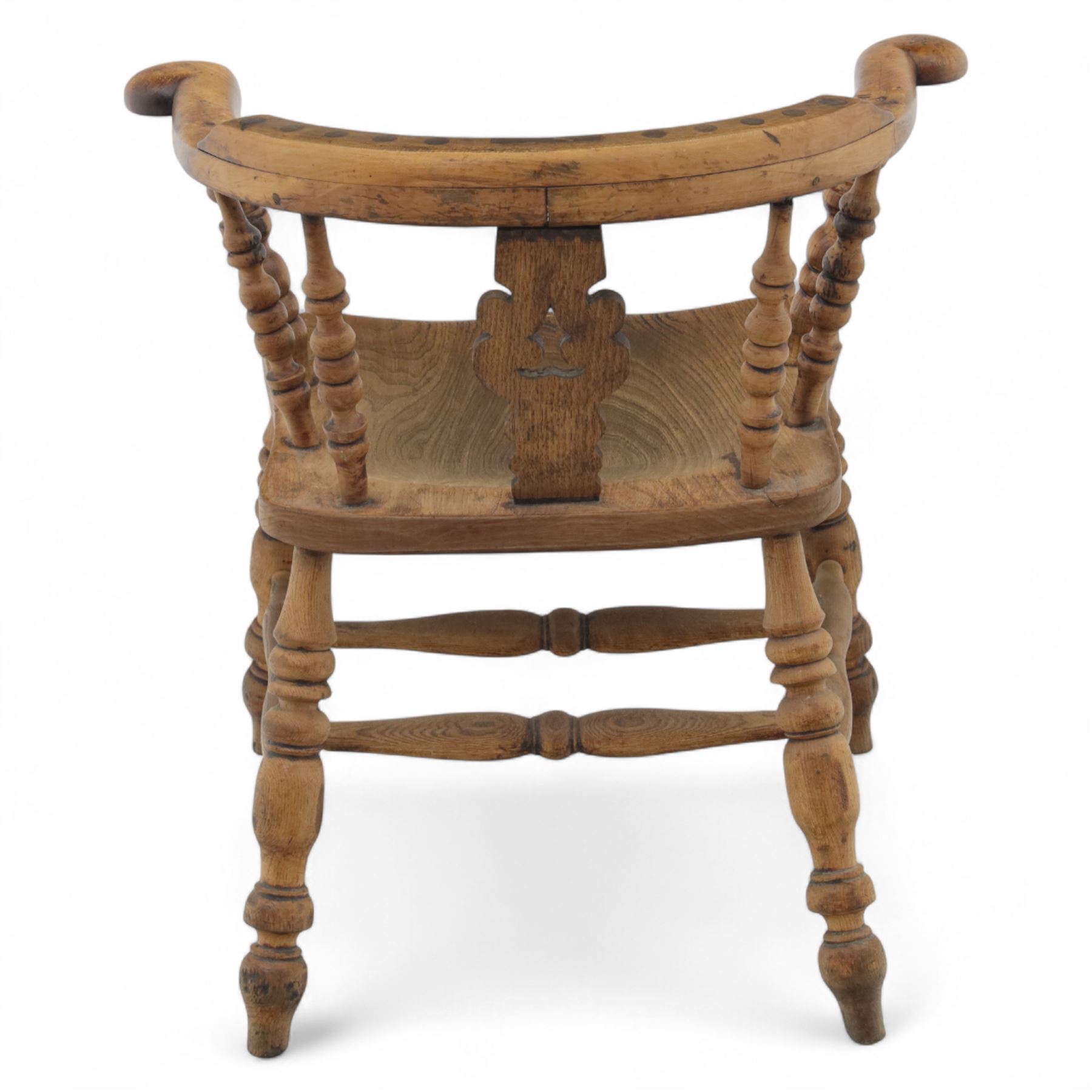 19th century ash and elm Windsor adapted armchair, continuous curved arm with turned spindle supports and shaped splat, saddle seat on turned legs united by crinoline stretcher