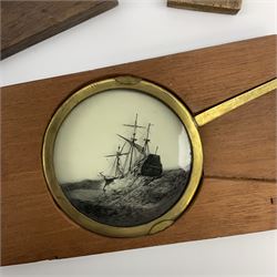 Two wood framed hand cranked rack and pinion chromatrope glass magic lantern slides, and a lever animated magic lantern slide depicting a galleon in a rough sea (3)
