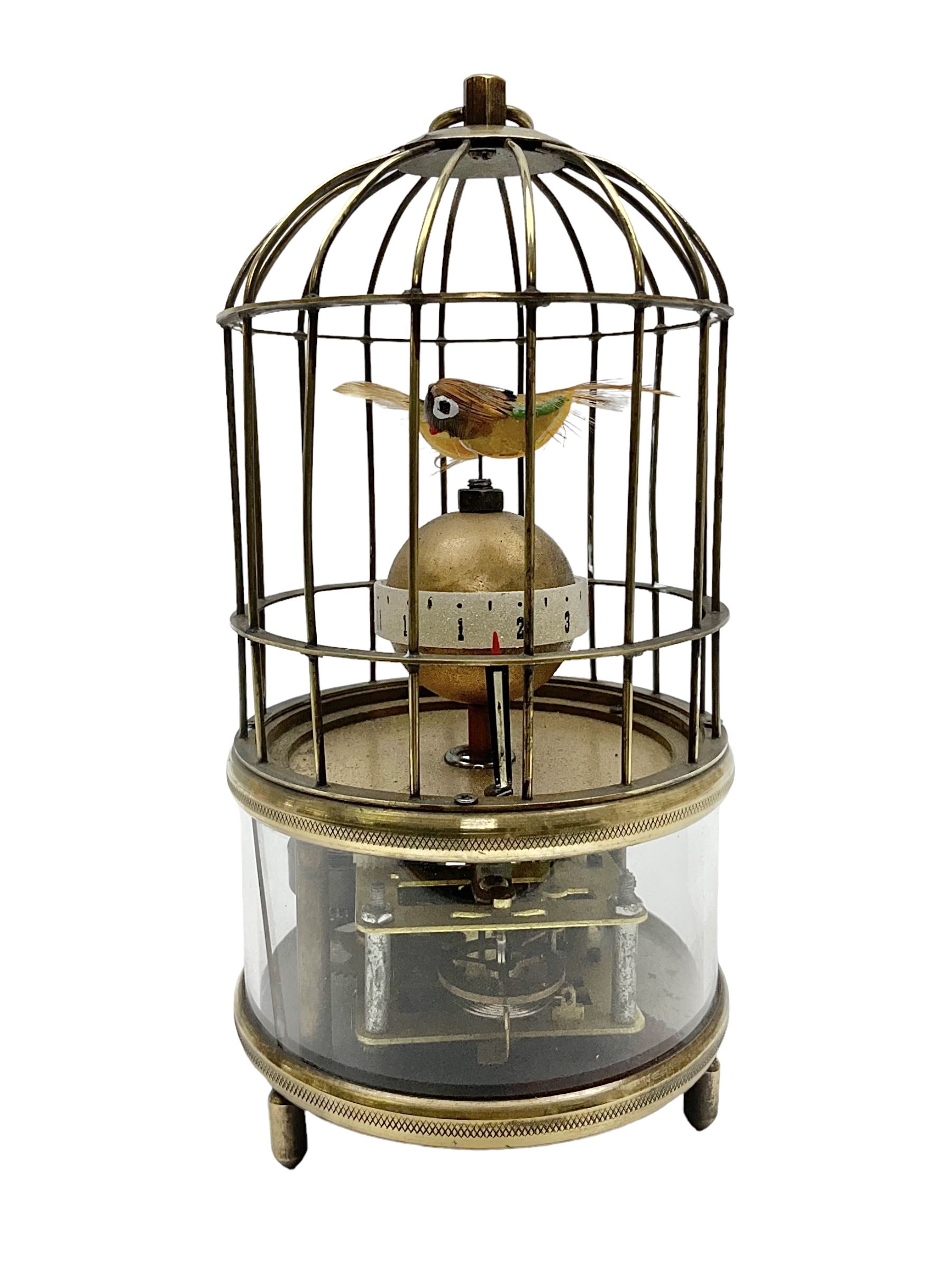 Automation bird cage clock of predominantly brass construction with central rotating orb and two birds with feathered decoration, H19cm