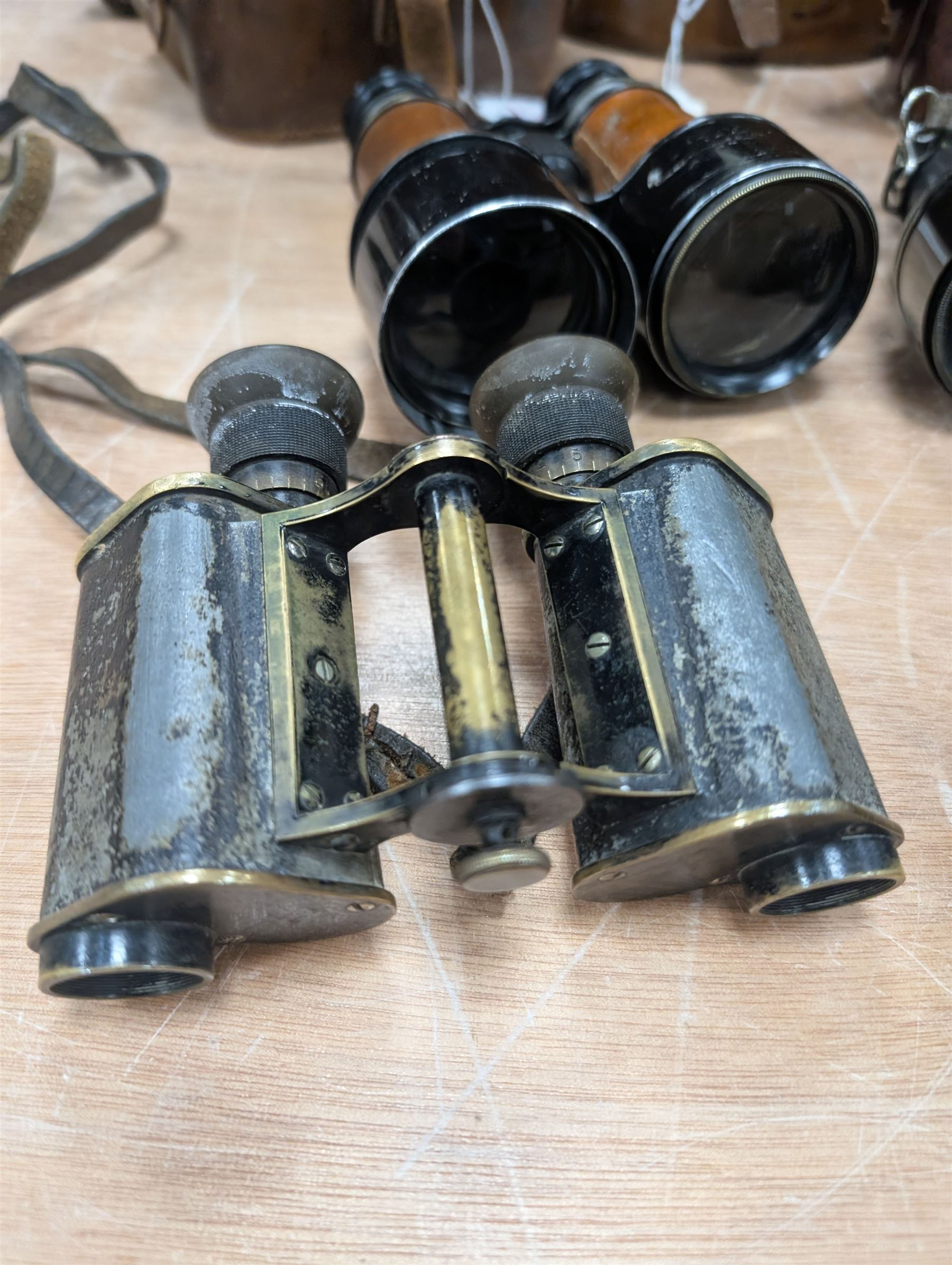 Four pairs of early 20th century binoculars, including Carl Zeiss Jena Feldstecher binoculars, Carl Zeiss Telact 8x binoculars, Dollond x5 field binolculars and one other pair, all in leather cases, one case marked with broad arrow, some with officers name etched
