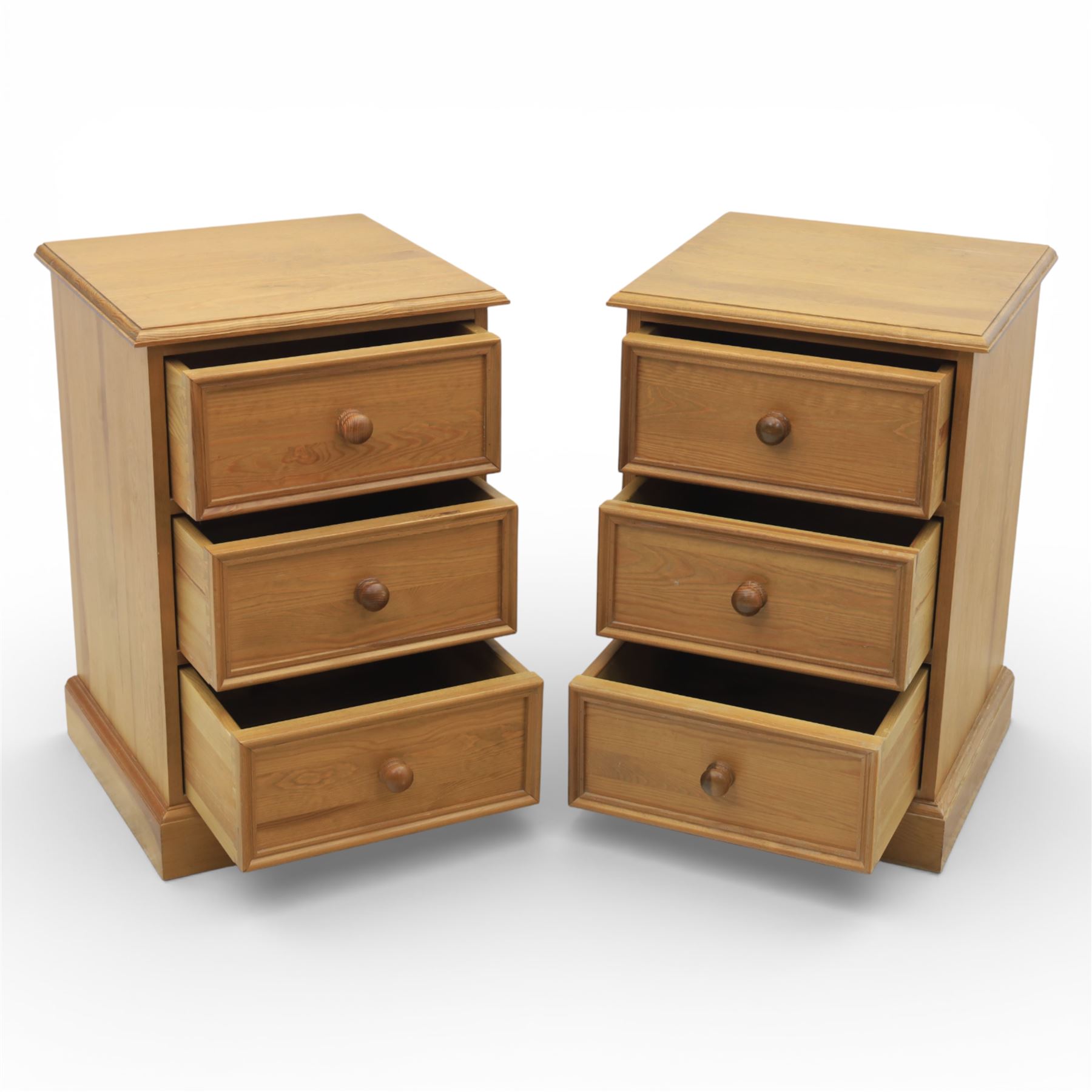 Pair of late 20th century waxed pine bedside chests, three drawers with moulded edges and turned pulls, raised on a plinth base 