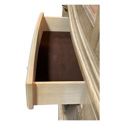 Brunswick - washed oak finish illuminated display cabinet, upper section with four glass-panelled doors enclosing glass shelving, base fitted with two drawers over four paneled cupboard doors, each fitted with distinctive round metal handles, raised on plinth base