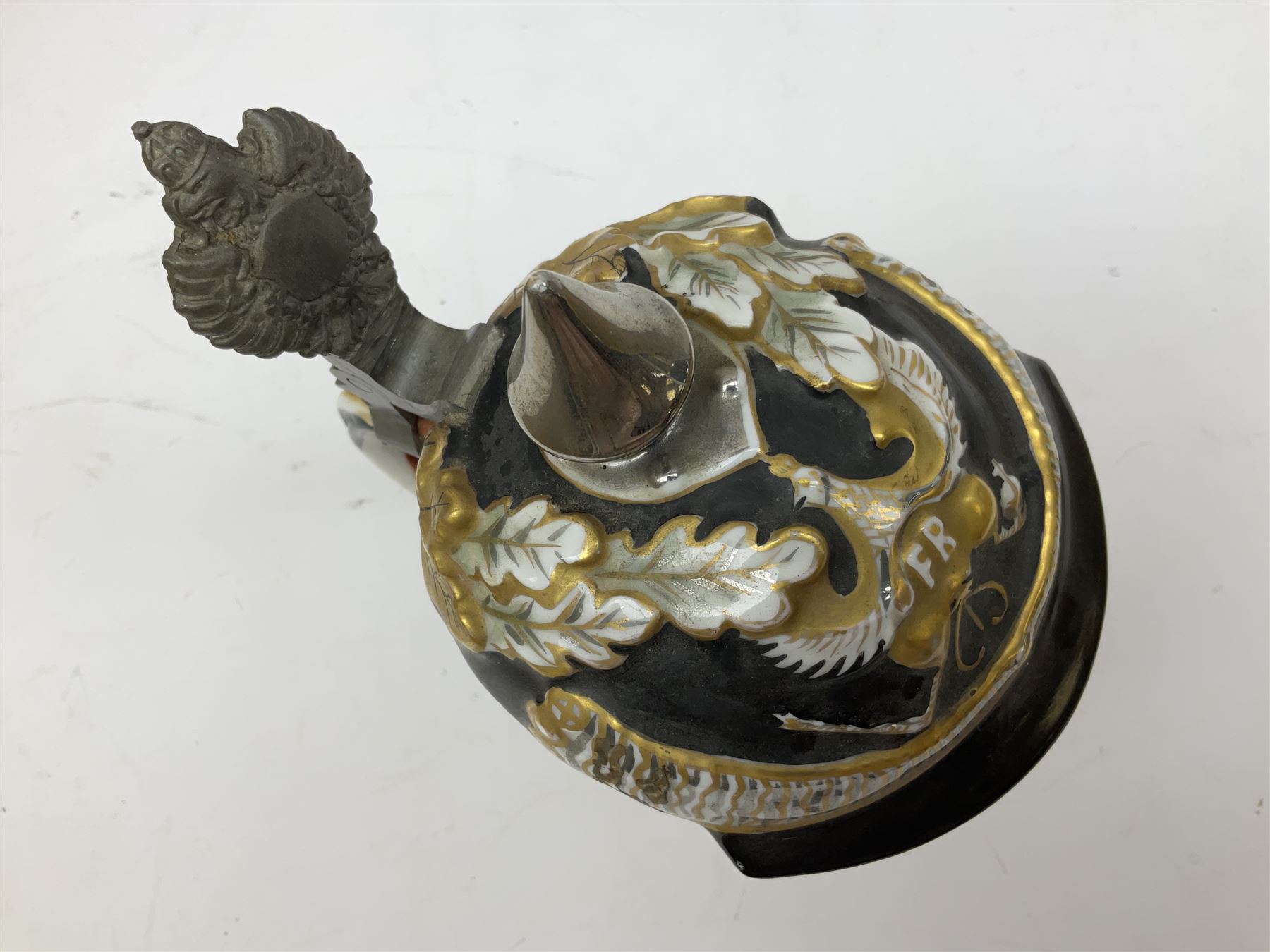 Otto Von Bismarck figural 0.5l stein, his black pickelhaube helmet with chrome spike serving as the lid, in green uniform and gilt detail throughout, pewter thumb hinge, with blue hash Musterschutz type mark, H18cm