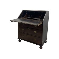 George III oak bureau, sloped fall-front enclosing a fitted interior with pigeonholes, small drawers, and a central compartment, over two short and two long drawers, brass escutcheons and drop handles, raised on bun feet