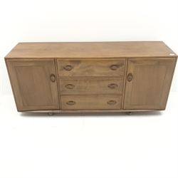 Ercol light elm sideboard, two cupboards flanking three drawers, W156cm, H69cm, D45cm