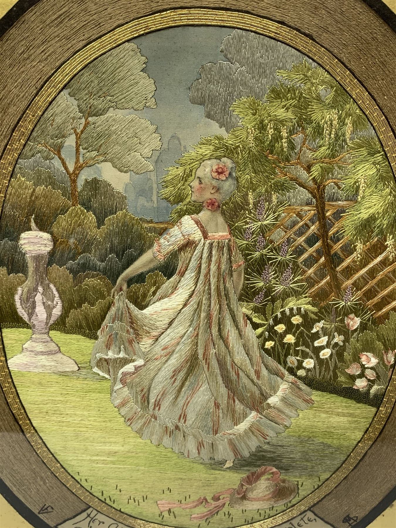 George III silkwork picture, of oval form depicting a female figure in garden setting, within a silkwork border detailed with verse from Robert Burns Bonnie Peg, 'Her air sae sweet, and shape complete, The Queen of Love did never move, Wi' Motion mair enchanting!', and monograms 'FV' and 'SM', in reeded gilt frame and gilt mount, indistinctly inscribed in pencil verso, overall H36cm L30.5cm
