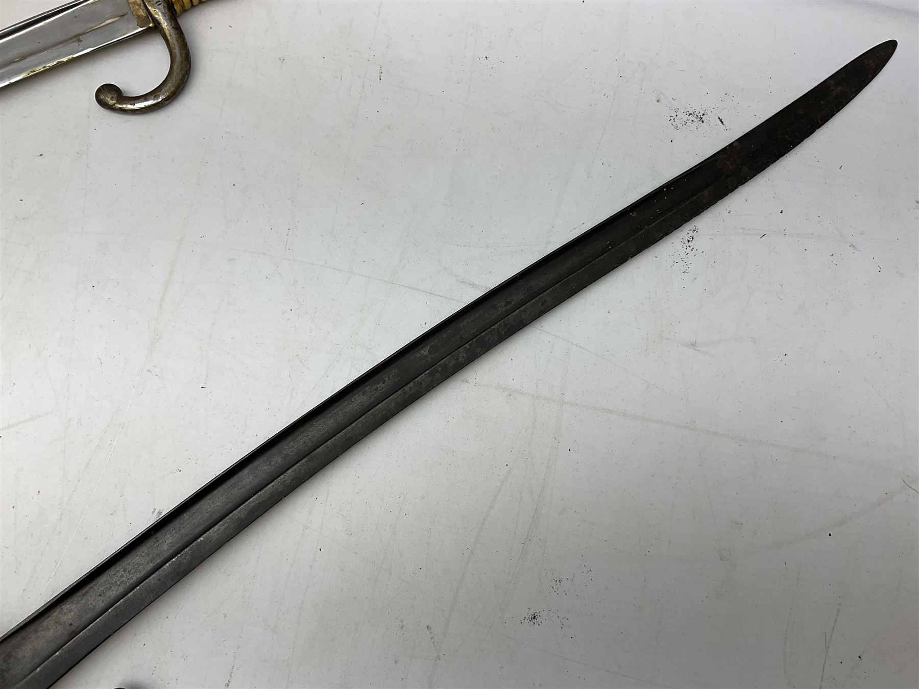 French Model 1866 sabre bayonet with 57cm fullered steel curving blade; in steel scabbard L71cm overall; another Model 1866 sabre bayonet lacking scabbard; and British Pattern 1856 sword bayonet (no scabbard) (3)