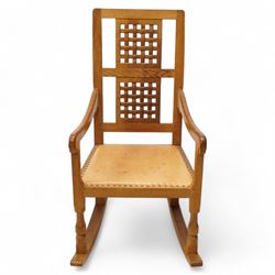 Mouseman - oak rocking armchair, double pierced and carved high lattice back, upholstered in tan leather with stud work, raised on octagonal front supports, carved with mouse signature, by the workshop of Robert Thompson, Kilburn

Provenance - this lot comes to us for sale from direct descent of Robert Thompson. Thompson is the great grandfather of the vendor.