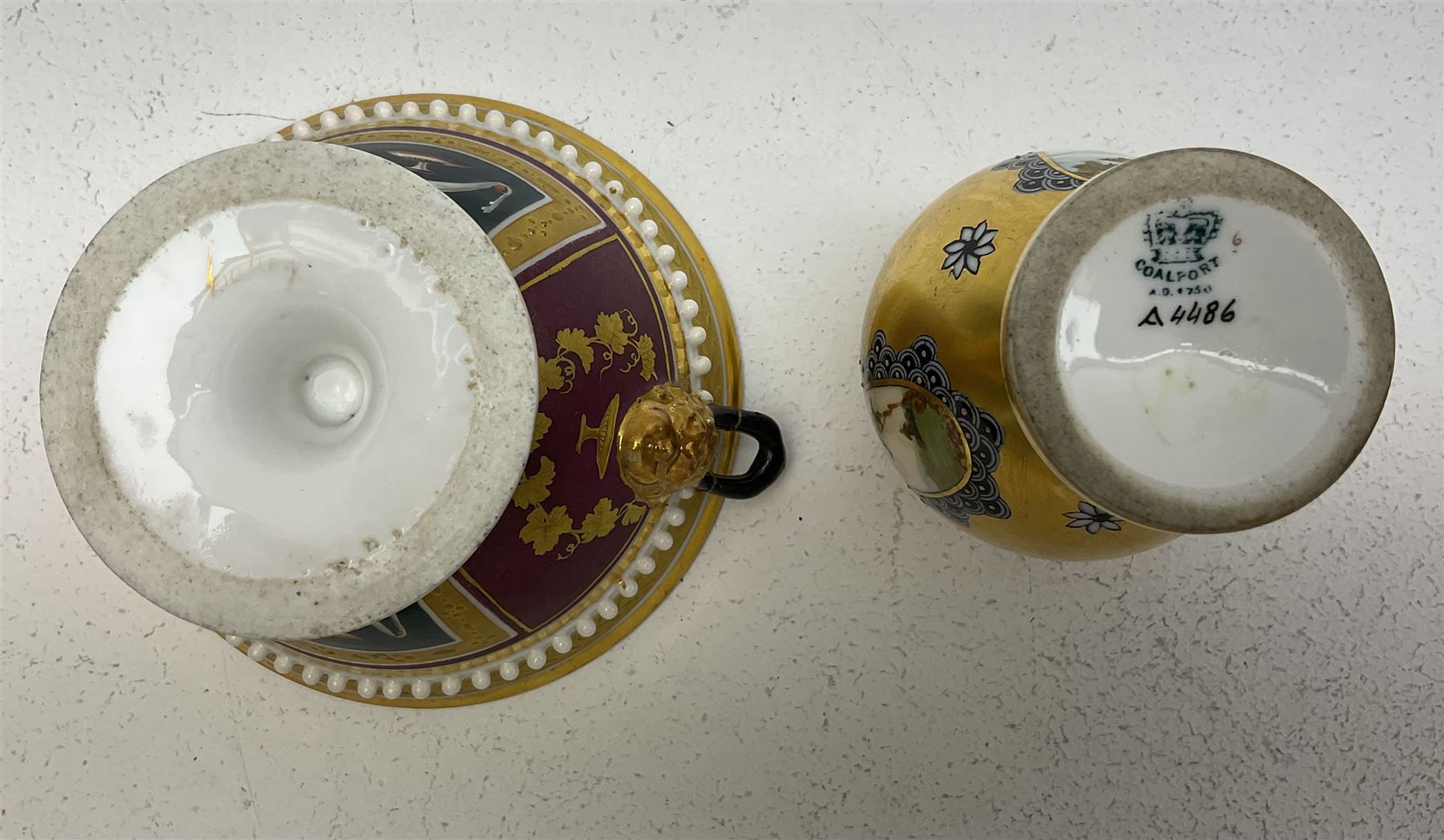 Small Coalport vase, decorated with painted landscape panels against a gilt ground, with printed mark beneath and painted number a4486, H8cm, together with a small Vienna style twin handled pedestal bowl, profusely gilded, H6.5cm