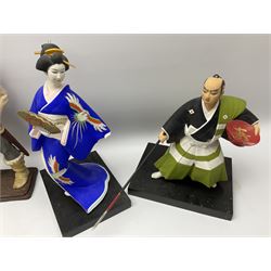 Clay Japanese Hakata dolls, comprising example modelled as a Geisha in blue kimono holding a fan, H41cm, another Geisha in pale pink kimono, H34cm, a Samurai, H35cm, and a composite figure of a Viking, H42.5cm. 