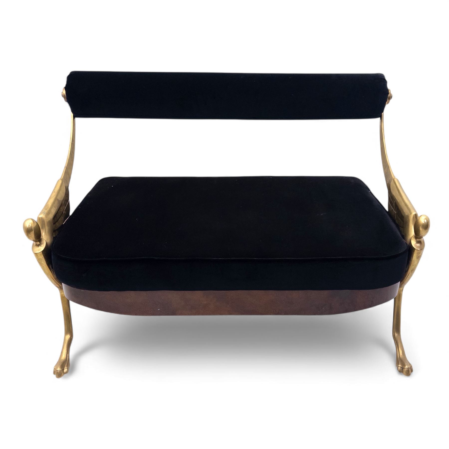 Late 20th century pair of Empire inspired brass metal framed two-seater sofas, upholstered in black velvet with cylindrical backrest and sphinx form arms terminating in paw feet, together with matching deep buttoned black velvet footstool on brass capped legs (Footstool H 38cm, W 70cm, D 70cm)